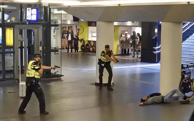 Dutch police officers point their guns at a wounded 19-year-old man, who was shot by police after stabbing two people in the central railway station, in Amsterdam, the Netherlands, August 31, 2018. (AP Photo) Dutch police officers point their guns at a wounded 19-year-old man, who was shot by police after stabbing two people in the central railway station, in Amsterdam, the Netherlands, August 31, 2018. (AP Photo)