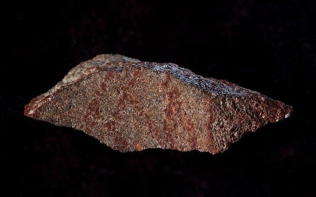 This undated photo provided by Craig Foster in September 2018 shows a drawing made with ochre pigment on silcrete stone, found in the Blombos Cave east of Cape Town, South Africa. (Craig Foster via AP) This undated photo provided by Craig Foster in September 2018 shows a drawing made with ochre pigment on silcrete stone, found in the Blombos Cave east of Cape Town, South Africa. (Craig Foster via AP)