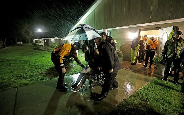 Members of the Nebraska Task Force 1 urban search and rescue team help load an elderly resident onto a bus as they evacuate an assisted living facility to a church as a precaution against potential flooding the city could see from tropical storm Florence in Fayetteville, North Carolina, Saturday, September 15, 2018. (AP Photo/David Goldman) Members of the Nebraska Task Force 1 urban search and rescue team help load an elderly resident onto a bus as they evacuate an assisted living facility to a church as a precaution against potential flooding the city could see from tropical storm Florence in Fayetteville, North Carolina, Saturday, September 15, 2018. (AP Photo/David Goldman)