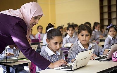 Illustrative: Palestinian children use laptops at the Ziad Abu Ein School in the West Bank city of Ramallah, September 8, 2018 (AP Photo/Majdi Mohammed)
