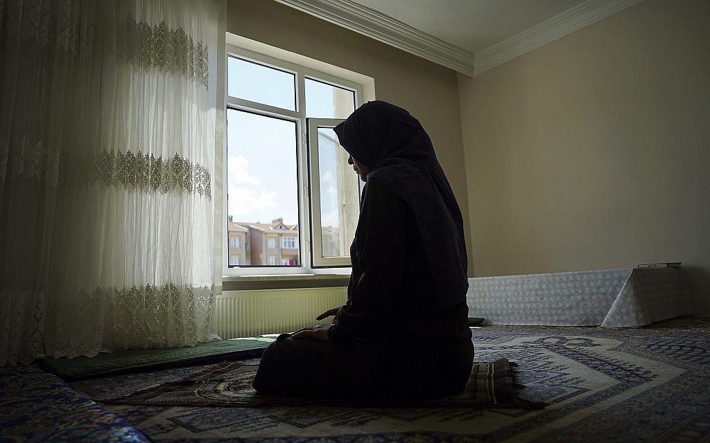 In this August 20, 2018, photo, Meripet, 29, prays at her home in Istanbul, Turkey. Meripet came to Turkey in February 2017 to visit her sick father, leaving four children behind. (AP Photo/Dake Kang) In this August 20, 2018, photo, Meripet, 29, prays at her home in Istanbul, Turkey. Meripet came to Turkey in February 2017 to visit her sick father, leaving four children behind. (AP Photo/Dake Kang)