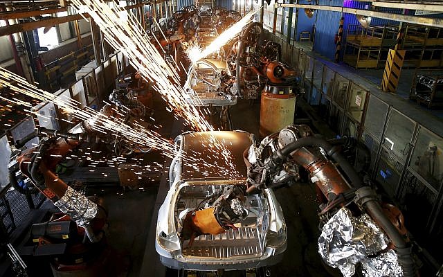 In this Sunday, September 9, 2018 photo, bodies of cars go through an assembly line at the Iran Khodro automobile manufacturing plant, just outside Tehran, Iran. (AP Photo/Ebrahim Noroozi)