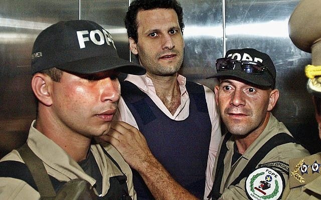 In this Nov. 17, 2003 file photo, Lebanese citizen Assad Ahmad Barakat, who was then facing tax evasion charges, is escorted by police to a courthouse in Asuncion, Paraguay. On Friday, Sept. 21, 2018, federal police in Brazil arrested Barakat, a fugitive accused of belonging to Lebanon's Hezbollah militia and of being a key financier of terrorism. (AP Photo/Jorge Saenz) In this Nov. 17, 2003 file photo, Lebanese citizen Assad Ahmad Barakat, who was then facing tax evasion charges, is escorted by police to a courthouse in Asuncion, Paraguay. On Friday, Sept. 21, 2018, federal police in Brazil arrested Barakat, a fugitive accused of belonging to Lebanon's Hezbollah militia and of being a key financier of terrorism. (AP Photo/Jorge Saenz)