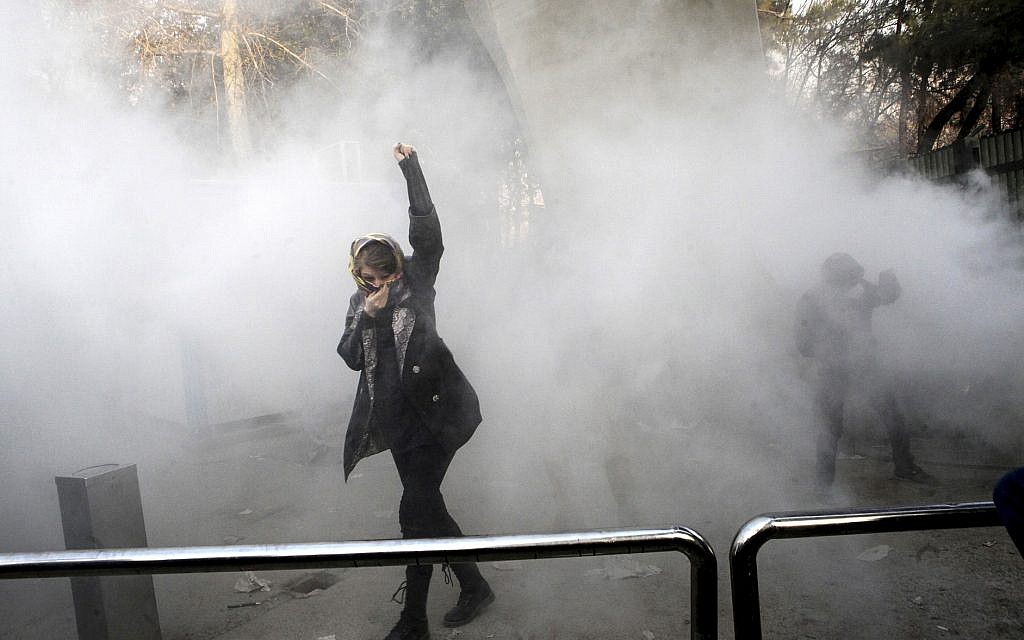 In this Dec. 30, 2017 file photo, taken by an individual not employed by the Associated Press and obtained by the AP outside Iran, a university student attends a protest inside Tehran University while a smoke grenade is thrown by anti-riot Iranian police, in Tehran, Iran (AP Photo, File) In this Dec. 30, 2017 file photo, taken by an individual not employed by the Associated Press and obtained by the AP outside Iran, a university student attends a protest inside Tehran University while a smoke grenade is thrown by anti-riot Iranian police, in Tehran, Iran (AP Photo, File)