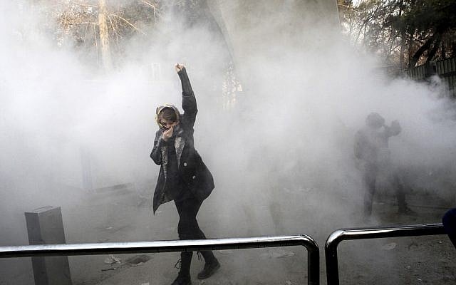 In this Dec. 30, 2017 file photo, taken by an individual not employed by the Associated Press and obtained by the AP outside Iran, a university student attends a protest inside Tehran University while a smoke grenade is thrown by anti-riot Iranian police, in Tehran, Iran (AP Photo, File) In this Dec. 30, 2017 file photo, taken by an individual not employed by the Associated Press and obtained by the AP outside Iran, a university student attends a protest inside Tehran University while a smoke grenade is thrown by anti-riot Iranian police, in Tehran, Iran (AP Photo, File)