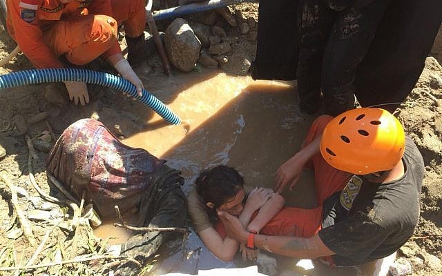 An Indonesian rescue team evacuates a women from damaged areas following earthquakes and a tsunami in Palu, Central Sulawesi, Indonesia, Sunday, September 30, 2018. (AP Photo/Chandra) An Indonesian rescue team evacuates a women from damaged areas following earthquakes and a tsunami in Palu, Central Sulawesi, Indonesia, Sunday, September 30, 2018. (AP Photo/Chandra)