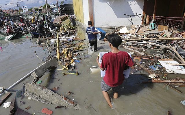 People carry items looted from a shopping mall badly damaged by a massive earthquake and tsunami in Palu, Central Sulawesi, Indonesia, Sunday, Sept. 30, 2018. (AP Photo/Tatan Syuflana) People carry items looted from a shopping mall badly damaged by a massive earthquake and tsunami in Palu, Central Sulawesi, Indonesia, Sunday, Sept. 30, 2018. (AP Photo/Tatan Syuflana)