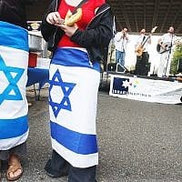 Illustrative: Two young women wear Israeli flags around their waists as a Jewish band plays at a pro-Israel gathering on the Rutgers University campus in New Brunswick, New Jersey campus, October 10, 2003. (AP Photo/Daniel Hulshizer)