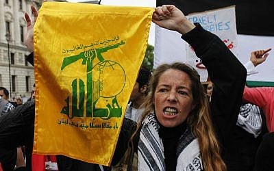 A pro-Palestinian supporter holds up a flag belonging to the Hezbollah group, during a march to protest against Israel in central London, May 31, 2010. (AP Photo/Lefteris Pitarakis)