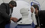 Jorge Cuadros, left, gives a demonstration of a robotic retinal camera to a reporter at the Google I/O conference in Mountain View, California, on May 8, 2018 (AP Photo/Jeff Chiu)