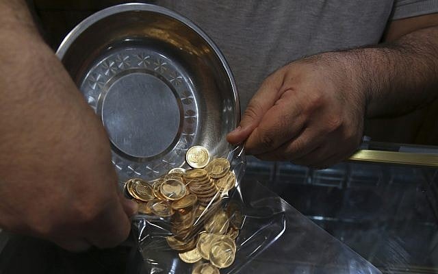 In this Wednesday, Aug. 12, 2018 photo, an Iranian goldsmith counts gold coins in the sprawling Grand Bazaar, that has seen customers eagerly buying gold as a hedge against the falling Iranian rial, in Tehran, Iran. Fear over the economy has brought many to the bazaar in recent days to buy what they can before their savings further dwindle away. (AP Photo/Vahid Salemi) In this Wednesday, Aug. 12, 2018 photo, an Iranian goldsmith counts gold coins in the sprawling Grand Bazaar, that has seen customers eagerly buying gold as a hedge against the falling Iranian rial, in Tehran, Iran. Fear over the economy has brought many to the bazaar in recent days to buy what they can before their savings further dwindle away. (AP Photo/Vahid Salemi)