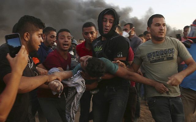 Protesters evacuate a wounded teenager near the fence of the Gaza Strip border with Israel during a protest east of Gaza City, September 14, 2018 (AP Photo/Adel Hana) Protesters evacuate a wounded teenager near the fence of the Gaza Strip border with Israel during a protest east of Gaza City, September 14, 2018 (AP Photo/Adel Hana)