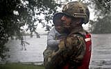Rescue team member Sgt. Nick Muhar, from the North Carolina National Guard 1/120th battalion, evacuates a young child as the rising floodwaters from Hurricane Florence threatens his home in New Bern, North Carolina, on September 14, 2018. (AP Photo/Chris Seward)