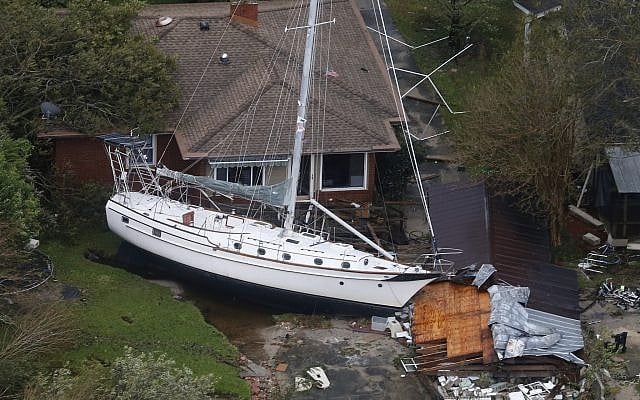 A sailboat is shoved up against a house and a collapsed garage Sept. 15, 2018, after heavy wind and rain from Florence, now a tropical storm, blew through New Bern, North Carolina (AP Photo/Steve Helber)