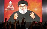 Hezbollah leader Sheik Hassan Nasrallah speaks via a video link, as his supporters raise their hands, during activities to mark the ninth of Ashura, a 10-day ritual commemorating the death of Imam Hussein, in a southern suburb of Beirut, Lebanon, on September 19, 2018. (AP Photo/Hussein Malla)