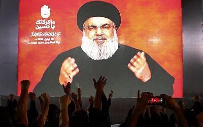 Hezbollah leader Sheik Hassan Nasrallah speaks via a video link, as his supporters raise their hands, during activities to mark the ninth of Ashura, a 10-day ritual commemorating the death of Imam Hussein, in a southern suburb of Beirut, Lebanon, on September 19, 2018. (AP Photo/Hussein Malla)