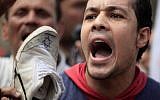 An Egyptian man chants slogans as he hold a shoe with an Israeli flag drawn on it during an anti-Israel protest held after the Friday noon prayer at Al-Azhar mosque in Cairo, Egypt, Friday, May 10, 2013. (AP/Khalil Hamra)