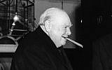 Sir Winston Churchill bites at one of his famous big cigars as he takes leave of prime minister Sir Anthony Eden after lunch at 10 Downing Street in London on Nov. 22, 1955 (AP Photo)