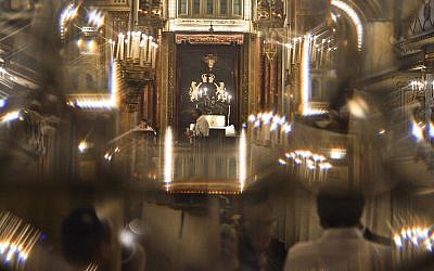 Romanian Jews, seen through a glass door, attend a religious service ahead of the Jewish holiday of Yom Kippur, the Day of Atonement, at the Great Synagogue in Bucharest, Romania, September 13, 2013. (AP Photo/Andreea Alexandru/Mediafax)
