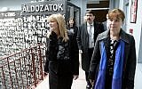 Hungarian President Janos Ader, center, and his wife, Anita Herczegh, right, are escorted by Maria Schmidt, left, as they tour the House of Terror museum to pay tribute on the memorial day for victims of communism in Budapest, Hungary, Wednesday, February 25, 2015. (AP Photo/MTI, Tamas Kovacs)