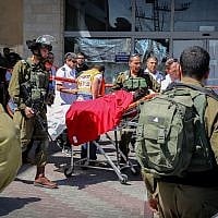Israeli soldiers and medics at the scene of a fatal terror stabbing next to the Gush Etzion Junction in the West Bank, on September 16, 2018. (Gershon Elinson/Flash90)