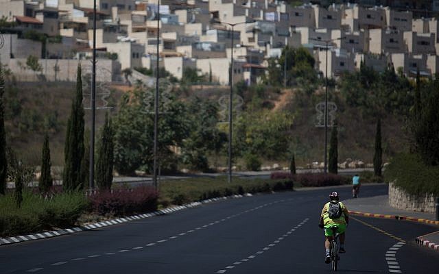 Israelis ride their bicycles along the empty road in Jerusalem on Yom Kippur, September 19, 2018 (Hadas Parush/Flash90)