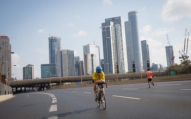 Israelis ride their bicycles along the empty Ayalon highway in Tel Aviv, on Yom Kippur, September 19, 2018 (Miriam Alster/Flash 90)