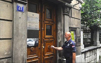 Serbian police officer provides security at the Belgrade headquarters of Serbia’s Federation of Jewish Communities, June 2018. (Larry Luxner/Times of Israel)