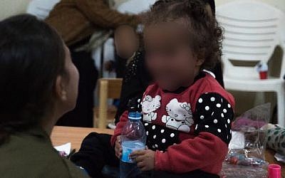 A Syrian child plays with an Israeli soldier as part of the IDF's 'Operation Good Neighbor' project, which helped thousands of Syrians before Israel shut it down after Syrian dictator Bashar Assad took control of the area bordering the Golan Heights. (Israel Defense Forces)
