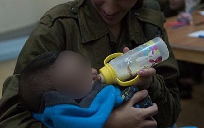 An IDF soldier feeds a Syrian baby as part of the IDF's 'Operation Good Neighbor' project, which helped thousands of Syrians before Israel shut it down after Syrian dictator Bashar Assad took control of the area bordering the Golan Heights. (Israel Defense Forces)