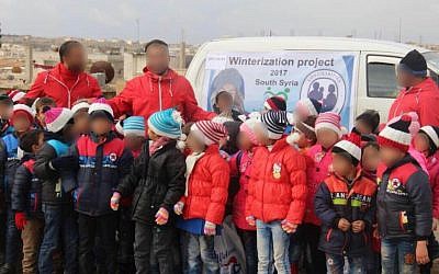 Syrian children show off the coats and winter clothes they received as part of the IDF's 'Operation Good Neighbor' project, 2017. (Israel Defense Forces)