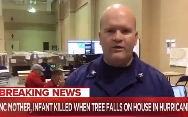 A coast guard member, in background, making an alleged white power gesture at the time of Hurricane Florence, September 15, 2018. (screen capture: Twitter) A coast guard member, in background, making an alleged white power gesture at the time of Hurricane Florence, September 15, 2018. (screen capture: Twitter)