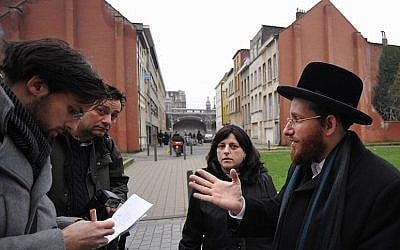 Moshe Friedman, right, talks to journalists with his wife Lea Rosenzweig outside Antwerp’s Benoth Jerusalem girls school in Belgium, Jan 7, 2018. (Cnaan Liphshiz/JTA)