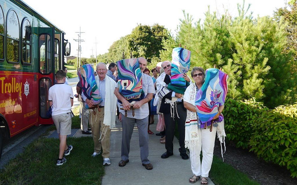 Temple Anshe Hesed congregants carry the Torah scrolls from their old building during a 'de-consecration' event on August 31, 2018. (Alanna Cooper/via JTA)