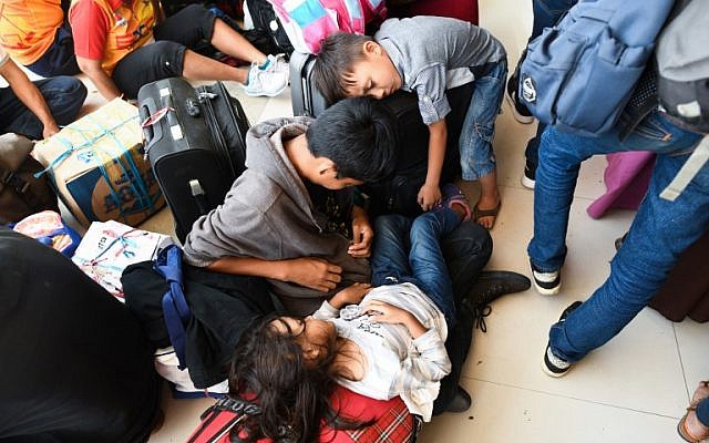 Survivors rest outside the airport as they wait to get a flight out of Palu, Indonesia's Central Sulawesi on October 1, 2018 (AFP PHOTO / Jewel SAMAD)
