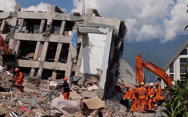Members of an Indonesian rescue team search for victims from collapsed buildings in Palu in Central Sulawesi, October 2, 2018. (YUSUF WAHIL/AFP)