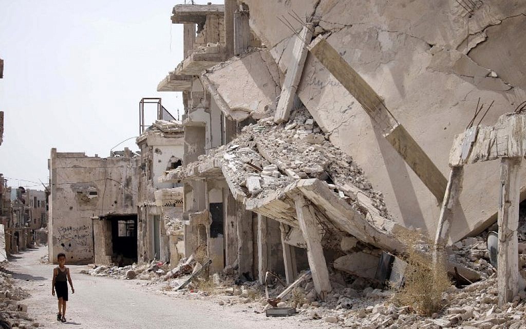 A Syrian child walks past the rubble of destroyed buildings in an opposition-held neighbourhood of the southern city of Daraa on October 2, 2018. (AFP/ Mohamad ABAZEED)