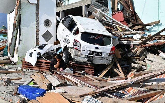A young quake survivor searches for salvageable items from the rubble of a residence in Lere subdistrict in Palu, Indonesia's Central Sulawesi on October 3, 2018. (ADEK BERRY/AFP) A young quake survivor searches for salvageable items from the rubble of a residence in Lere subdistrict in Palu, Indonesia's Central Sulawesi on October 3, 2018. (ADEK BERRY/AFP)