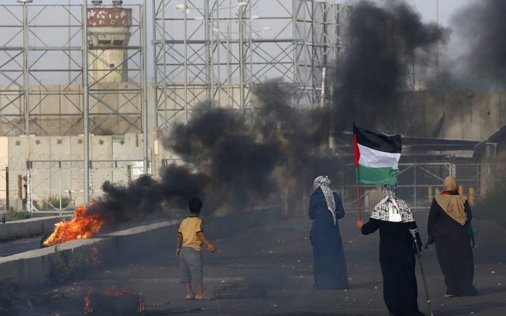 A Palestinian woman holds a flag as protesters demonstrate at the Erez border crossing with Israel in the northern Gaza Strip on October 3, 2018. (AFP/ Said KHATIB)