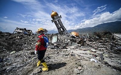 An Indonesian search and rescue member walks near a collapsed mosque at Perumnas Balaroa village in Palu in Central Sulawesi on October 6, 2018, following the September 28 earthquake and tsunami (AFP PHOTO / MOHD RASFAN)