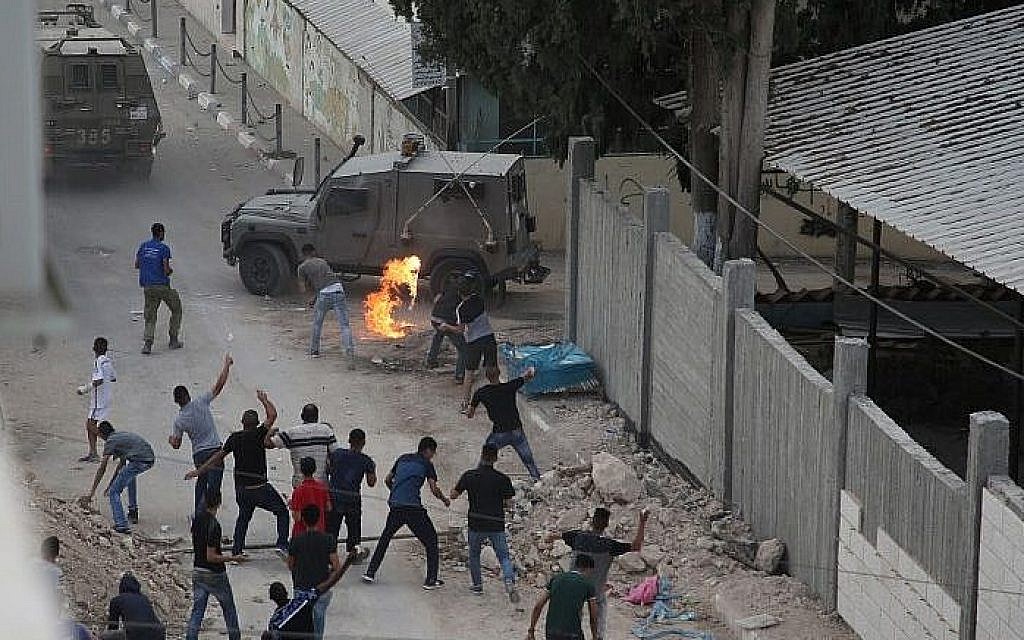 Palestinians throw stones and molotov cocktails at Israeli forces in the West Bank village of Shuweika on October 7, 2018. (AFP Photo/Jaafar Ashtiyeh)