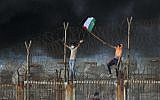 Palestinian protestors place their national flag on a metal structure during a demonstration on the beach near the maritime border with Israel, in the northern Gaza Strip, on October 8, 2018. ( Said KHATIB / AFP)
