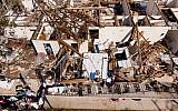 A man works though the remains of an apartment in the aftermath of Hurricane Michael October 11, 2018 in Panama City, Florida. (Photo by Brendan Smialowski / AFP)