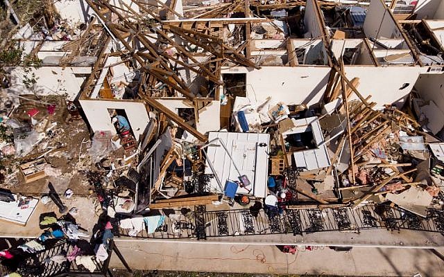 A man works though the remains of an apartment in the aftermath of Hurricane Michael October 11, 2018 in Panama City, Florida. (Photo by Brendan Smialowski / AFP)