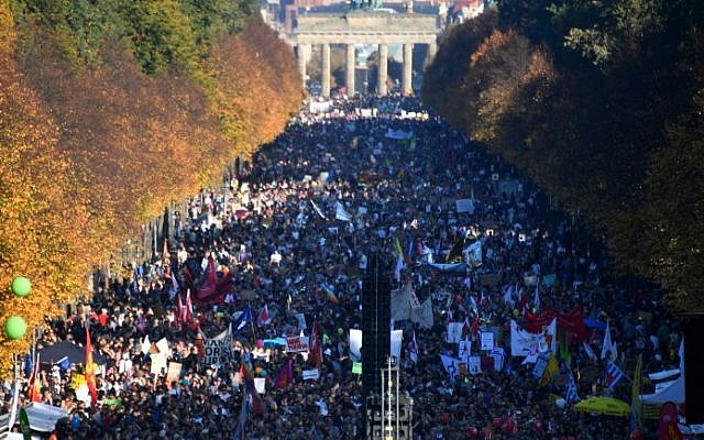 Demonstrators gather in Berlin's Tiergarten district between the Brandenburg Gate and the Victory Column during a major demonstration for an open and caring society organized by the action group "Unteilbar" (indivisible) on October 13, 2018. (John MACDOUGALL / AFP) Demonstrators gather in Berlin's Tiergarten district between the Brandenburg Gate and the Victory Column during a major demonstration for an open and caring society organized by the action group "Unteilbar" (indivisible) on October 13, 2018. (John MACDOUGALL / AFP)