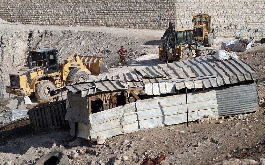 An Israeli soldier stands next to excavators in the West Bank Bedouin village of Khan al-Ahmar on October 16, 2018. (Ahmad Gharabli/ AFP)