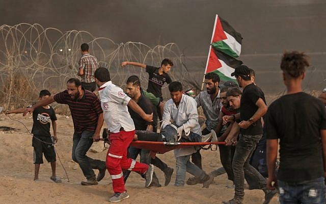 Palestinian paramedics carry an injured protester during a demonstration near the border with Israel, east of Gaza City, on October 19, 2018. (Mahmud Hams/AFP) Palestinian paramedics carry an injured protester during a demonstration near the border with Israel, east of Gaza City, on October 19, 2018. (Mahmud Hams/AFP)