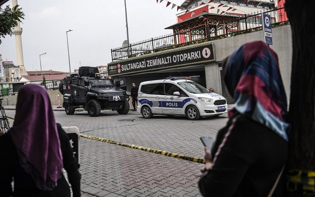 Women look as Turkish police stand guard as they cordoned off an underground car park, on October 23, 2018 in Istanbul, where an abandoned car belonging to the Saudi consulate has been found, three weeks after the murder of journalist Jamal Khashoggi in the Saudi consulate. (OZAN KOSE / AFP)