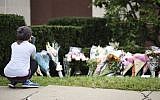 The day after a deadly shooting, a woman looks at flowers as part of a memorial outside of the Tree of Life synagogue, on October 28, 2018. (Brendan SMIALOWSKI/AFP)
