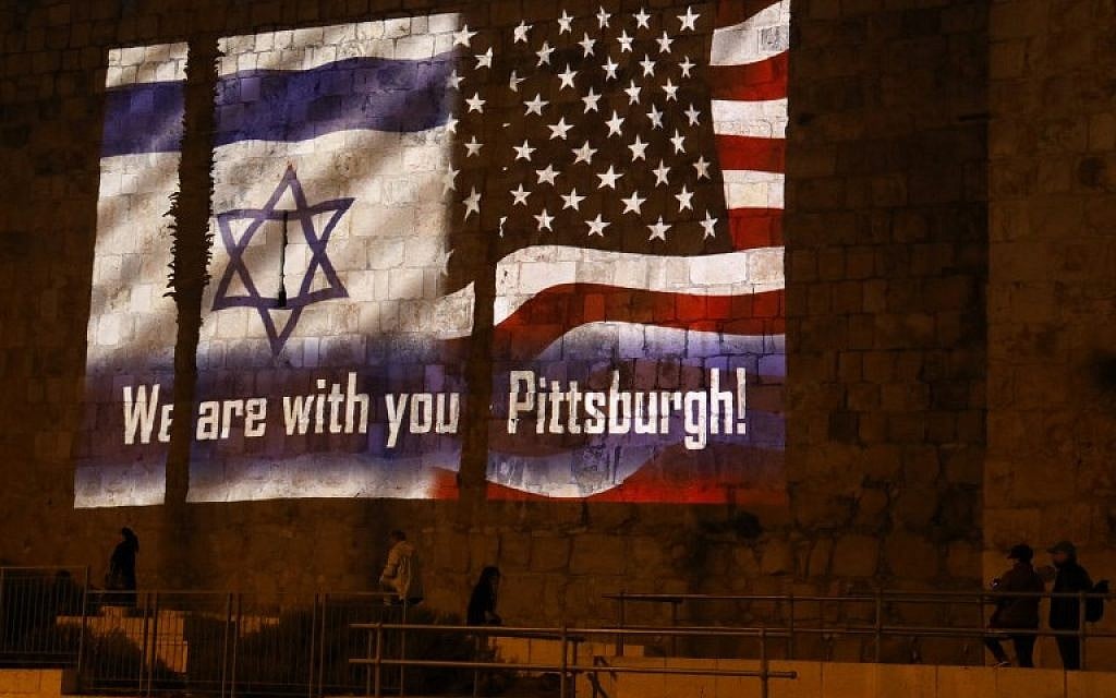 People walk under the US and the Israeli flags projected on the walls of Jerusalem's Old cCity on October 28, 2018. (Photo by Menahem KAHANA / AFP)